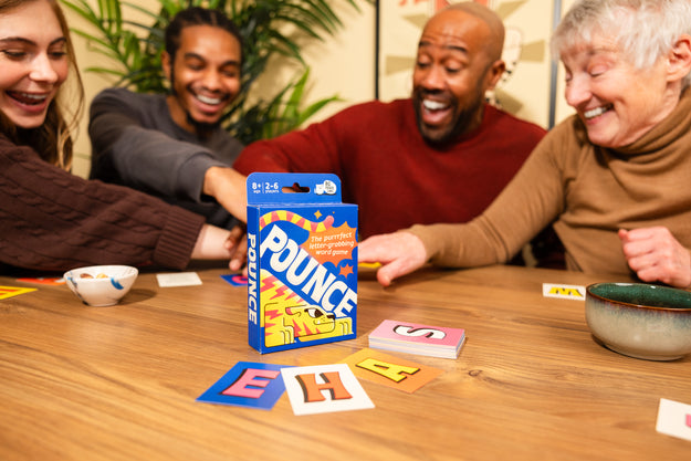 Pounce card game with a family playing the game in the background